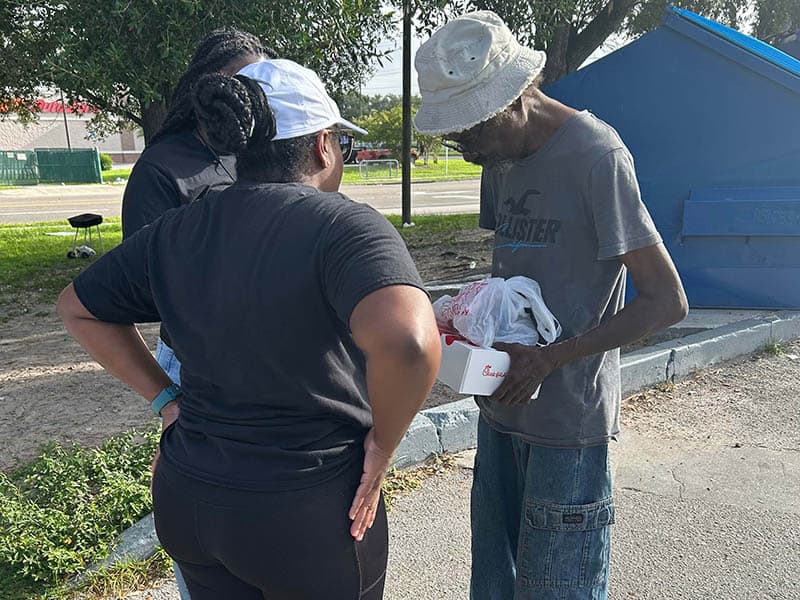 Watchmen of the Outpouring volunteers distributing food and essentials in a community outreach event.