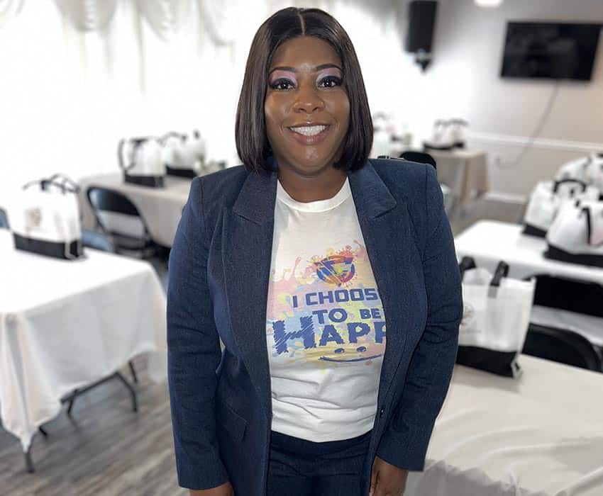 Empowered woman smiling at Watchmen of the Outpouring, Inc. event in a professional setting.